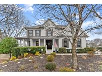 Charming two-story home with a cozy front porch, shutters, and professionally landscaped front yard at 6310 Fox Creek Dr, Cumming, GA 30040