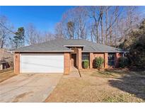 Brick ranch house with attached garage and landscaped yard at 1440 Teaberry Cir, Lawrenceville, GA 30044