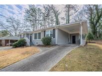 Gray brick ranch home with carport and landscaped yard at 1937 Windsor Sw Dr, Atlanta, GA 30311