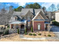 Brick two-story home with stone accents, a large front porch, and a landscaped yard at 2976 Cambridge Hill Dr, Dacula, GA 30019