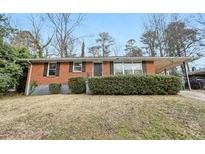 Brick ranch house with a well-maintained lawn and shrubs at 1820 Arkose Dr, Atlanta, GA 30316