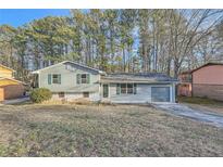 Ranch style home with gray siding, attached garage, and mature trees at 2536 Nw Ridgecrest Dr Nw, Kennesaw, GA 30152