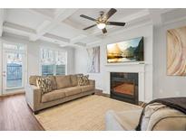 Bright living room featuring a coffered ceiling, fireplace, large windows, and comfortable seating at 86 Trailview Ln, Hiram, GA 30141