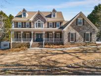 Two-story brick home with a wraparound porch and landscaped yard at 1300 Bridgewater Walk, Snellville, GA 30078