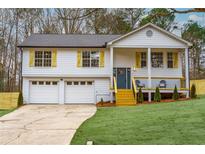 Newly renovated house featuring a gray door, wooden deck, and two-car garage at 319 Primrose Ln, Auburn, GA 30011
