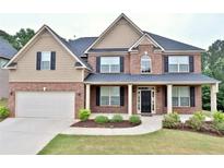 Beautiful two-story brick home with covered front porch and manicured landscaping at 4300 Henry Rd, Snellville, GA 30039