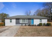 Newly renovated ranch home with gray and white exterior, landscaping, and a blue front door at 914 Clay Sw Rd, Mableton, GA 30126