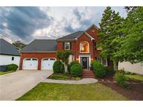 Charming two-story red brick home with a manicured front lawn and attached two car garage at 4222 Honey Creek Way, Powder Springs, GA 30127