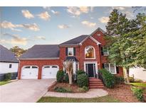Brick two-story house with a three-car garage and landscaped front yard at 4222 Honey Creek Way, Powder Springs, GA 30127