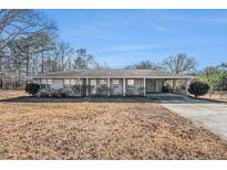 Ranch-style home with carport and mature trees at 6747 Rockland Rd, Lithonia, GA 30038