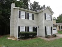 Two-story house with gray siding, black shutters, and a landscaped yard at 3090 Windwood Trl, Lawrenceville, GA 30044