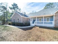 Charming single-story home featuring a brick facade, covered front porch, and well-maintained landscaping at 4801 Daniel Mill Rd, Winston, GA 30187