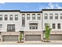Modern townhome with brick accents, two-car garage, covered entry, and black window trim at 215 Arizona Ne Ave # 2, Atlanta, GA 30307