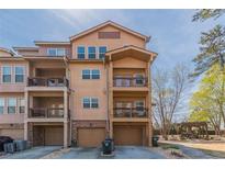 Three-story townhome featuring private balconies, a front-entry garage and a well-maintained lawn at 3021 Quantum Ln, Chamblee, GA 30341