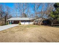 Charming single-story home with a brick facade, attached carport, and a spacious front lawn at 4453 White Oak Dr, Sugar Hill, GA 30518