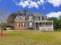 Charming two-story home featuring a classic design and well-maintained lawn at 305 Rampart St, Mcdonough, GA 30253