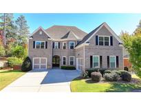 Brick two-story house with a three-car garage and manicured lawn at 1190 Smithwell Pt, Kennesaw, GA 30152
