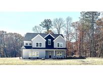 Charming two-story home with gray siding, black accents, large windows and an inviting front porch nestled in a wooded area at 4863 Amsler Rd, Ellenwood, GA 30294