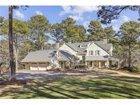 Expansive home boasts a three-car garage, front porch, and a sprawling lawn shaded by mature trees at 11461 Hackett Rd, Roswell, GA 30075