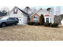 Brick and vinyl sided house with a two-car garage and well-manicured lawn at 1935 Charleston Oak Cir, Lawrenceville, GA 30043