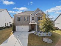 Two-story home with gray brick and shutters, landscaped yard, and driveway at 2144 Woodmarsh Cir, Auburn, GA 30011