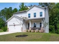 Charming two-story home features a covered porch, stone accents, a two-car garage, and a well-maintained front yard at 63 Brookstone E Park, Acworth, GA 30101