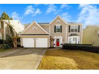 Two-story house with beige siding, two-car garage, and landscaped yard at 4206 Cornell Nw Xing, Kennesaw, GA 30144