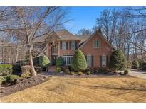 Brick house with two-car garage, manicured lawn, and basketball court at 920 Riverhaven Dr, Suwanee, GA 30024