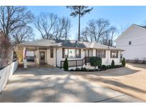 Charming single-story home featuring a covered carport, a cozy front porch, and beautiful landscaping at 1454 Pierce Se Ave, Smyrna, GA 30080