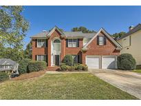 Brick two-story house with a two-car garage and landscaped lawn at 3314 Mill Grove Ter, Dacula, GA 30019