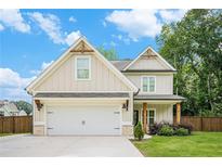 Charming two-story home with a two-car garage, a manicured lawn, and craftsman architectural details at 61 Harmony Woods Ln, Dallas, GA 30157