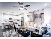 Open living room with kitchen, fireplace, and neutral decor at 3342 Orwell Way # 1405, Cumming, GA 30041
