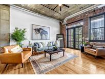 Spacious living room with exposed brick, modern furniture, and plenty of natural light at 3180 Mathieson Ne Dr # 703, Atlanta, GA 30305