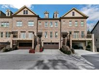 Brick front three-story townhome with attached garage and balcony at 3128 Chestnut Woods Dr, Atlanta, GA 30340