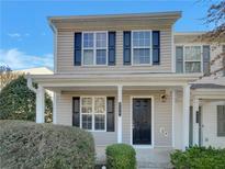 Tan two-story home with black shutters and a covered porch at 720 Crestwell Sw Cir, Atlanta, GA 30331