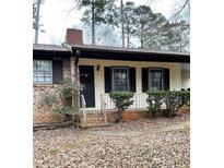 Charming home with a brick and siding exterior, covered front porch, and well-maintained landscaping at 40 Chimney Rise Ct, Stockbridge, GA 30281