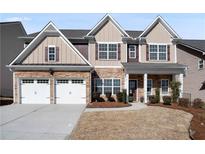 Charming two-story home with stone accents, a two-car garage, and a well-maintained front yard at 6170 Pierless Lndg, Sugar Hill, GA 30518