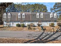 Front view of a light blue multi-Gathering home with grey roof and mature trees at 6406 Abercorn St, Union City, GA 30291