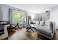 Bright living room with hardwood floors, gray sectional sofa, and large window at 4701 Flat Shoals Rd # 57A, Union City, GA 30291