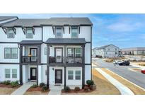Two-story townhome with white siding, black accents, and a front balcony at 1000 Knoxboro Ln, Woodstock, GA 30188