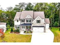 Charming brick home featuring a well-manicured lawn, attached garage, and beautiful landscaping at 1102 Sweet Mia Ln, Powder Springs, GA 30127