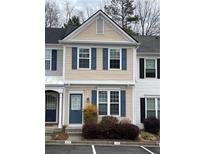 Tan and white two-story townhome with blue shutters and landscaping at 211 Buckland Dr, Alpharetta, GA 30022