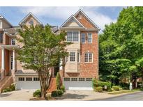 Brick front exterior of a three-story townhome with a two-car garage at 1028 Emory Parc Pl, Decatur, GA 30033