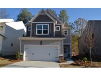 Two-story house with gray siding, white garage door, and landscaping at 4265 Easter Lily Ave, Buford, GA 30519