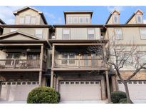 Tan three-story townhome with multiple balconies and attached garage at 3204 Saute Way, Avondale Estates, GA 30002