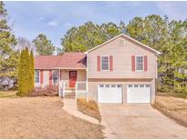 Tan two-story house with red shutters, double garage, and landscaped yard at 108 Ivy Trace Ln, Dallas, GA 30157