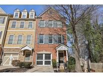 Brick front townhouse with a two-car garage and landscaping at 2329 Marion Walk Se Dr, Atlanta, GA 30339