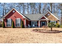 Red-sided house with gray roof, stone accents, and landscaping at 9 Glory Ln, Powder Springs, GA 30127