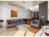 Bright living room features hardwood floors, gray sofa, and a spacious layout at 943 Peachtree Ne St # 902, Atlanta, GA 30309