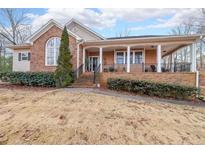 Brick ranch house with a large front porch and landscaped yard at 9545 Grande Dr, Winston, GA 30187